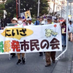 三軒屋公園前を歩くデモ隊