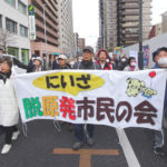 シュプレヒコールをあげて歩く参加者