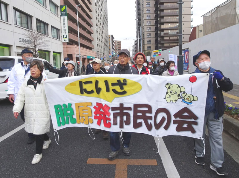シュプレヒコールをあげて歩く参加者